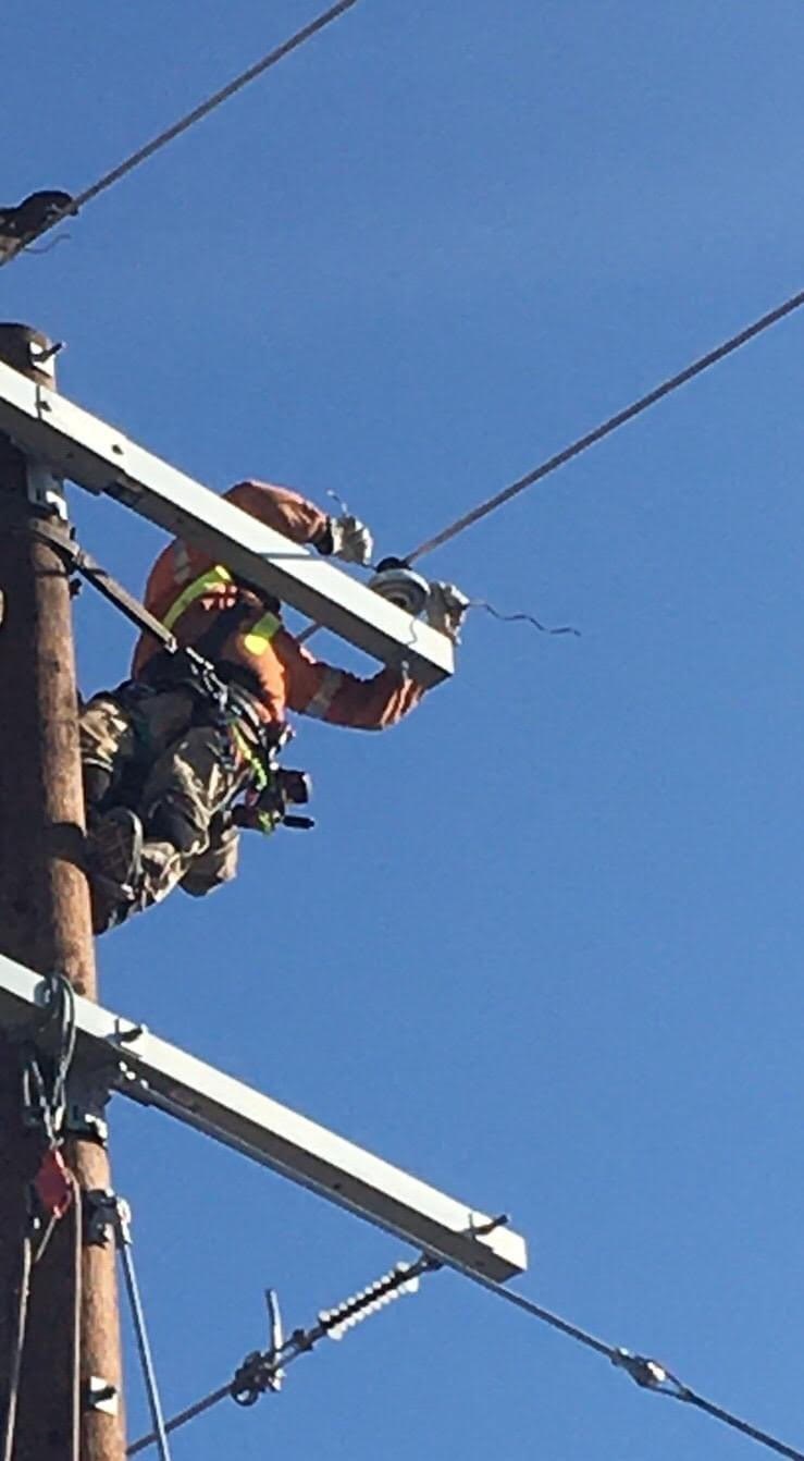 Powerline worker performing field work aloft